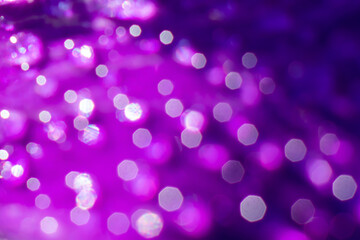 Blurred christmas background with bright purple backdrop with gowing glitters