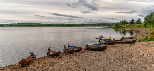 panorama view of many wooden motorboats used for salmon fishing on the banks of the Tornionjoki...