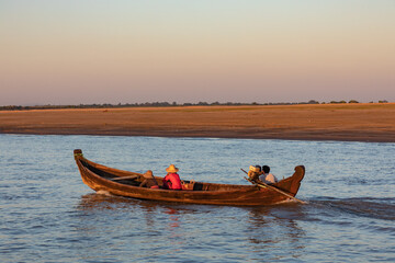 Einheimische im hölzernen Motorboot fahren entlang des Irrawaddy Flusses bei Mingun in Myanmar