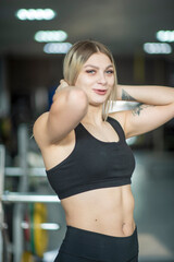 Fototapeta na wymiar Young beautiful blonde girl posing in the gym.