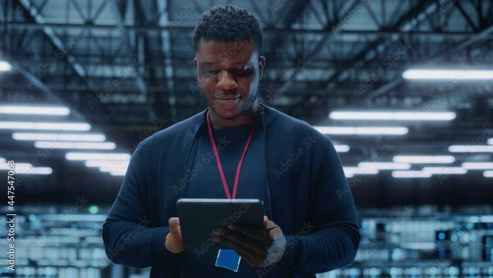 Aufkleber Portrait of a Data Center Engineer Using Laptop Computer. Server Room Specialist Facility with African American Male System Administrator Working with Data Protection Network for Cyber Security.
