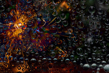 Transparent spheres are illuminated by a flash of orange light and are located against a dark green background. Space abstraction. 3D render.