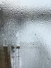 view from the window wet glass covered with wet flowing water, snow melts water drops