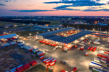 Aerial view of a logistics park with a  loading hub. A lot of semi-trailer trucks standing at...