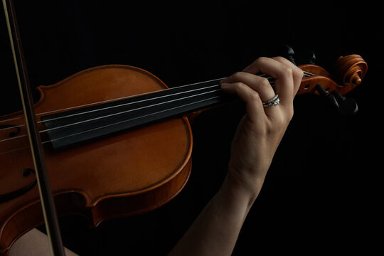 Closeup of Woman Playing the Violin in the Dark