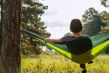 Tourist woman in a hammock in the forest