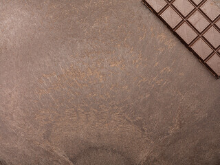 milk chocolate on a dark table. Chocolate bar. Top view. Copy space