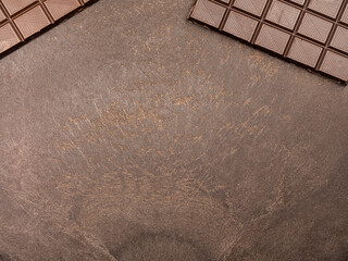 milk chocolate on a dark table. Chocolate bar. Top view. Copy space
