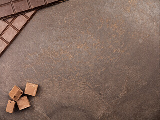 milk chocolate on a dark table. Chocolate bar. Top view. Copy space