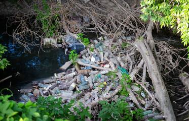 Environmental pollution plastic, glass waste in the river.