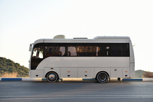empty comfortable middle bus parked on highway in mountains on sky background
