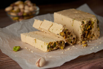 Organic halva with pistachios on a wooden surface. Traditional middle eastern sweets. Jewish,...