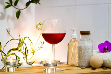Spa-beauty salon, wellness center. Spa treatment aromatherapy for the female body in the bathroom with a glass of wine, with candles, oils and salt