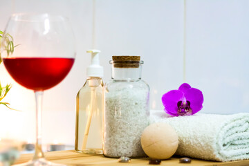 Obraz na płótnie Canvas Spa-beauty salon, wellness center. Spa treatment aromatherapy for the female body in the bathroom with a glass of wine, with candles, oils and salt