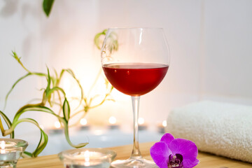 Spa-beauty salon, wellness center. Spa treatment aromatherapy for the female body in the bathroom with a glass of wine, with candles, oils and salt