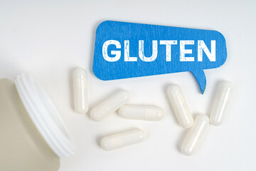 On the table are pills and a blue sign that says - gluten
