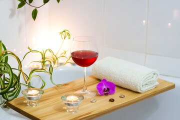 Spa-beauty salon, wellness center. Spa treatment aromatherapy for the female body in the bathroom with a glass of wine, with candles, oils and salt