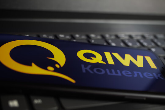 Viersen, Germany - June 1. 2021: Closeup of mobile phone screen with logo lettering of russian online payment service qiwi on computer keyboard