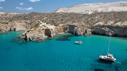 Obraz premium Aerial drone photo of beautiful volcanic emerald paradise bay and sandy beach of Tsigrado below white rock with perlite mine, Milos island, Cyclades, Greece
