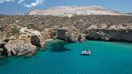 Aerial drone photo of beautiful volcanic emerald paradise bay and sandy beach of Tsigrado below white rock with perlite mine, Milos island, Cyclades, Greece