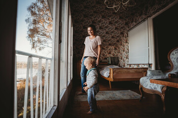 Mother and child in vintage bedroom with flower wallpaper