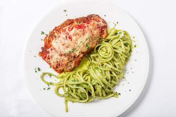 Chicken with parmesan cheese and linguine pasta in pesto sauce