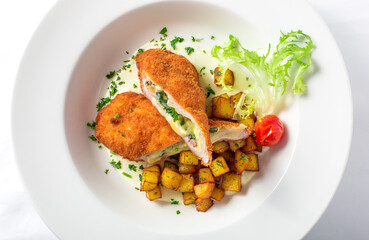 Cutting cordon bleu with cheese, turkey, crackers crumbs, potatoes.