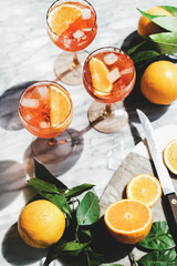 Aperol Spritz cocktail in glasses with oranges, top view