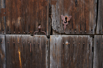 Antique wooden door with rusted hardware