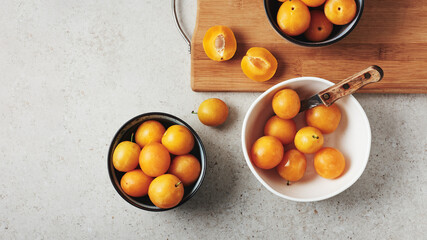 Ripe yellow mirabelle plums in bowls.
