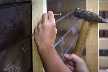 We hammer a nail into the board with a hammer.
