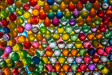 Fototapeta na wymiar Backlit colored balls with honeycomb textured interior