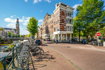 A typical Dutch street with bicycles parked alongside a canal in Amsterdam, Netherlands, with the...