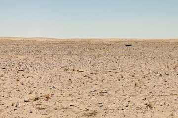 Fototapeta na wymiar Flat dry, sandy, rocky, barren, hot desert