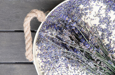 dry lavender on a beige tray on a wooden table top view