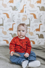 Fototapeta premium baby child sitting on the floor and playing with his toys in the children's room
