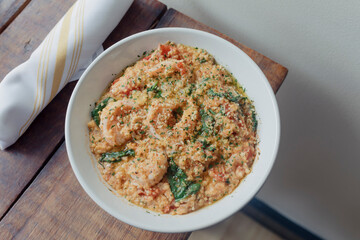 A bowl of shrimp and grits inside of a restaurant 