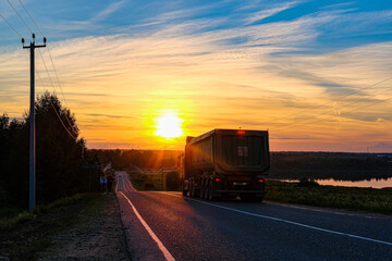 Moscow region, Russia - June, 16, 2021:  trucks on a country road in Moscow region at sunset