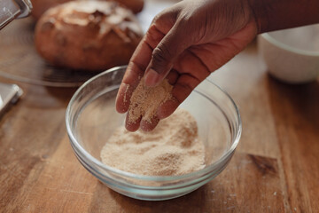 Flour on hand next to a glass mixing bowl