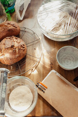 Bread loaves, bread dough and a baking notes on a worktable in a home kitchen