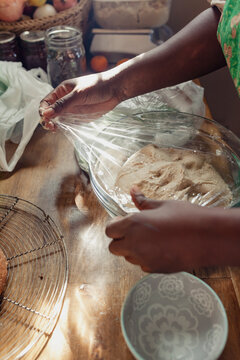 Hands of a home baker proofing bread dough