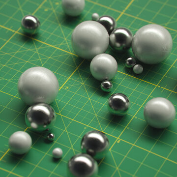 Metallic spheres glass pearls cuttting mat grid composition
