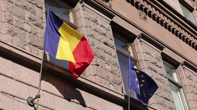 Romania flag and European Union flag side by side fluttering in the wind