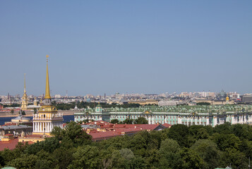Fototapeta na wymiar Panoramic top view of historical buildings-the Winter palace and the Admiralty spire among the green foliage of trees on a sunny summer day and a space for copying