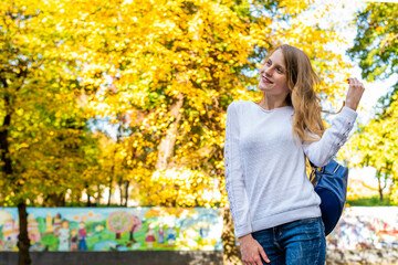 Happy teenage school child hold blue backpack on autymn city background, knowledge day.