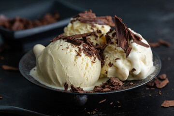 Vanilla ice cream scoops on dark plate
