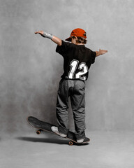 a young guy jumping on a skateboard with the number 12 on his jersey - 447572616