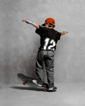 a young guy jumping on a skateboard with the number 12 on his jersey