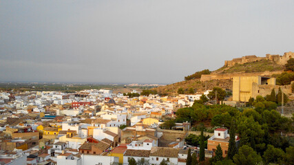 panoramic view of a city in the mountains, one day with clouds in the sky.