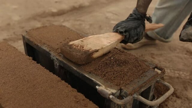 Worker ceramist making bricks for use as backgrounds in mosaic creating.
